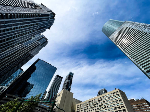 As I stand looking up at an impressive group of tall skyscrapers with a bright blue sky beautifully painted in the background above them