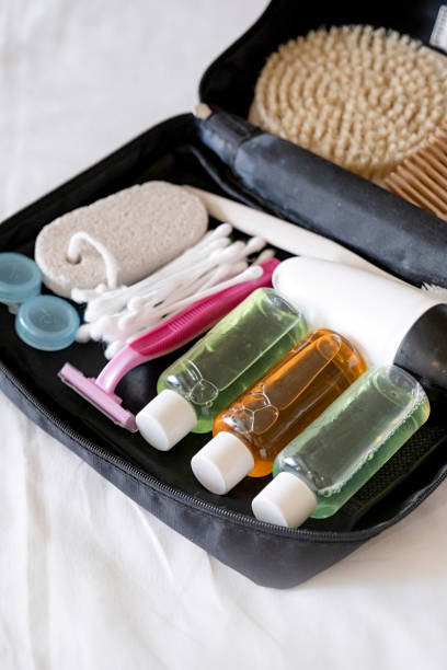 istock Travel cosmetics kit with bottles, brushes and cosmetics on bed 2180482809