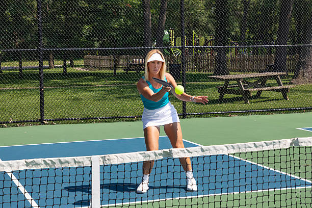 istock Female pickleball player returns ball at net 2180487891