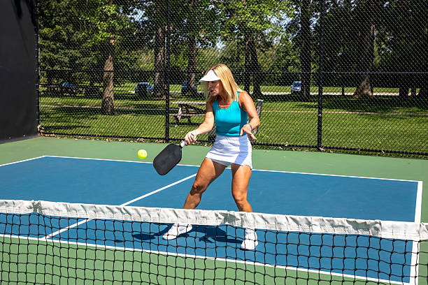 istock Female pickleball player returns ball at net 2180487903