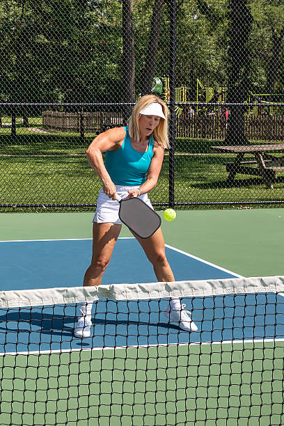 istock Female pickleball player returns ball at net 2180487905