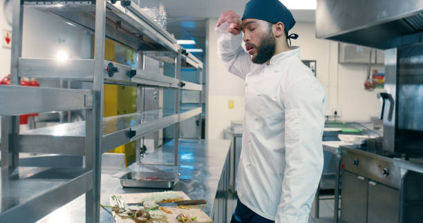 istock Man, chef and tired at restaurant in kitchen for cooking, gourmet or vegetables for culinary art with fatigue. Person, meal prep and burnout at night with stress, food or catering services at bistro 2180491420