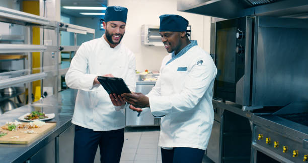 istock Men, chef and discussion with tablet at restaurant in kitchen for cooking, gourmet or app for culinary art at diner. Person, meal prep and touchscreen for advice, food and catering services at bistro 2180491507