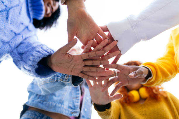 istock Group of young people joining hands together in a teamwork gesture 2180491665