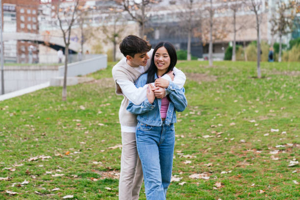 istock Young multiethnic couple hugging in a park 2180492293