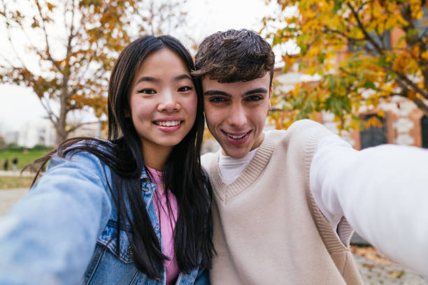 istock Young couple taking a selfie in autumn park 2180492357