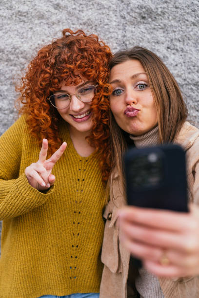 istock Two young women taking a selfie and making funny faces 2180493076