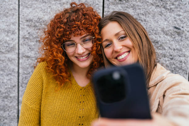 Two female friends taking a selfie with smartphone