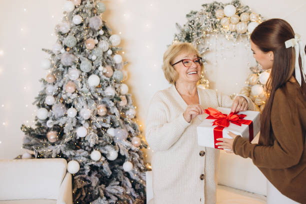 istock Joyful Family Christmas Gift Exchange by the Tree 2180497571