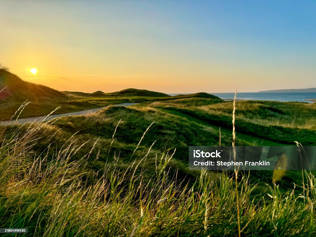 A sunset over a golf course with a smooth road passing through - Royalty-free Landschap - Buiten de steden gelegen gebied Stockfoto A sunset over a golf course with a smooth road passing through - Royalty-free Landschap - Buiten de steden gelegen gebied Stockfoto