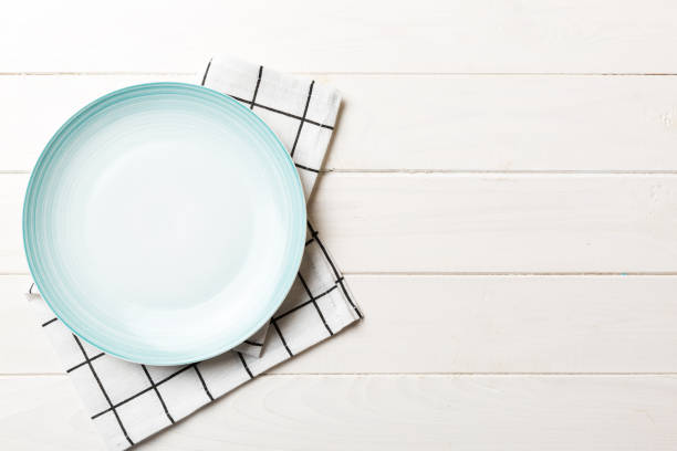 istock Top view on colored background empty round blue plate on tablecloth for food. Empty dish on napkin with space for your design 2180500148