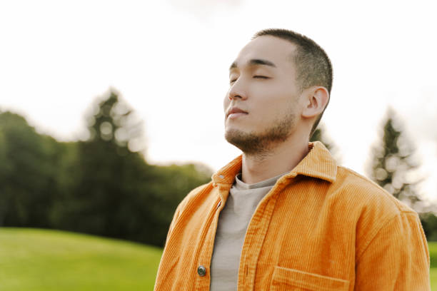 istock Young man breathing fresh air in nature taking a deep breath 2180501960