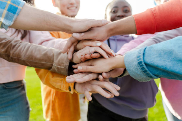 istock Group of people joining hands in teamwork gesture 2180502049