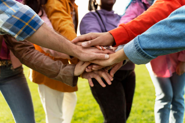 istock Group of diverse people joining hands in unity 2180502050