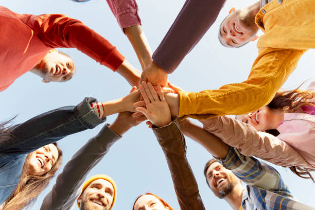 istock Group of people joining hands forming a circle outdoors 2180502054