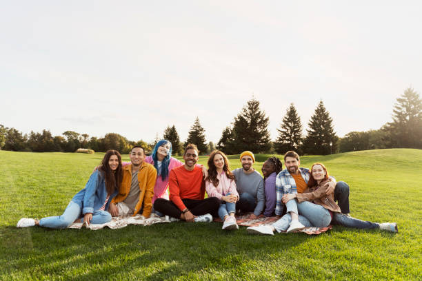 istock Group of diverse young people relaxing together in a park 2180502065