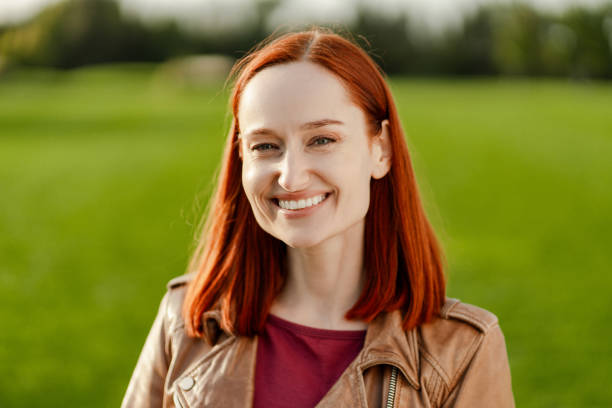 istock Beautiful redhead woman smiling outdoors in a field 2180502116