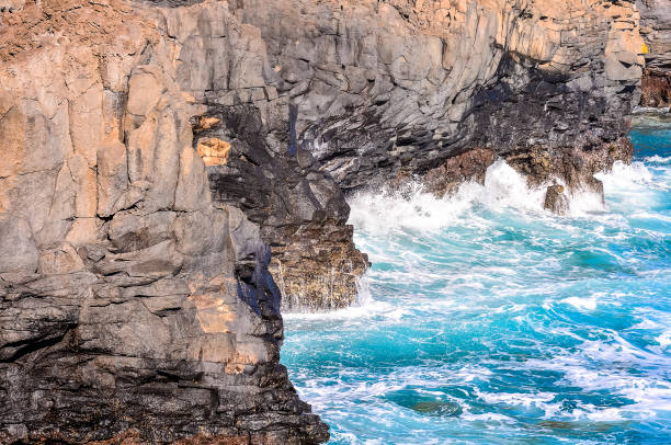 istock A rocky shoreline with a large wave crashing into the rocks 2180504910