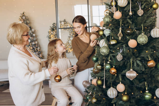 istock Family Decorating Christmas Tree in Cozy Living Room Setting 2180505358