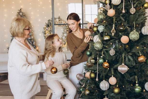 istock Family Decorating Christmas Tree in Cozy Living Room Setting 2180505383