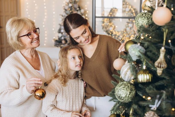 istock Three Generations Decorating Christmas Tree Together at Home 2180505504