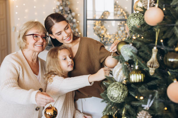 istock Three Generations Decorating Christmas Tree Together at Home 2180505517