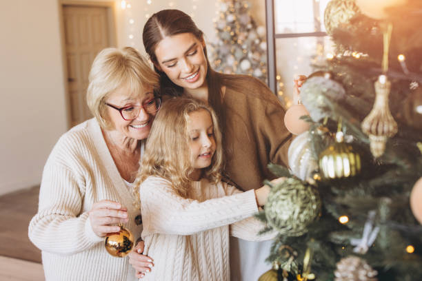 istock Family Decorating Christmas Tree Together With Joyful Smiles 2180505529