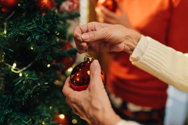 istock Senior women decorating christmas tree with red baubles 2180506471