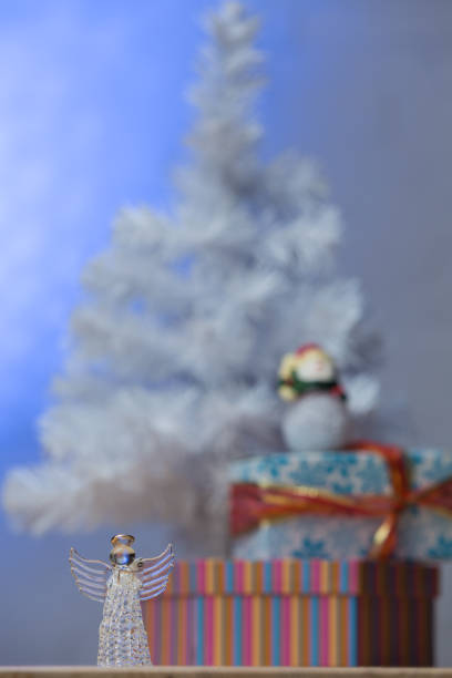 Christmas angels and balls with weaving on the background of a Christmas tree, handmade decor in an eco-style, hands close-up, top view