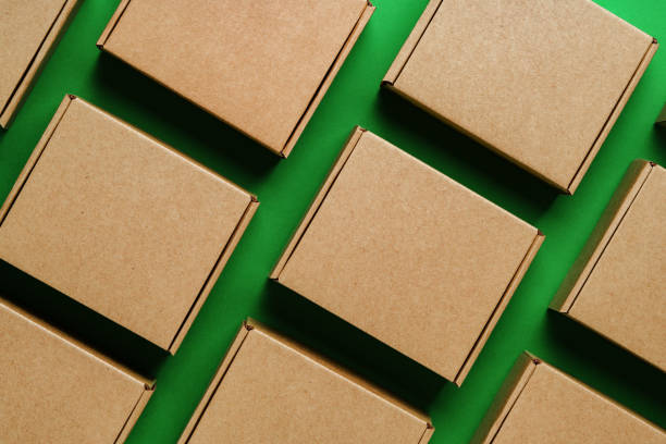 istock Brown cardboard boxes arranged on a vibrant green surface 2180507132