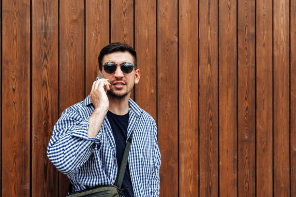 Man in sunglasses smiling while talking on his phone close up