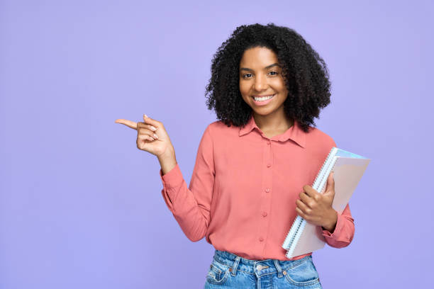 istock Happy young African American student model pointing isolated on purple. 2180507768