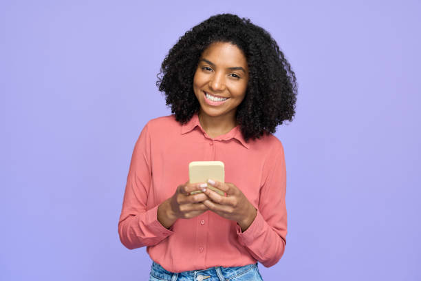 istock Young happy African gen z model using phone isolated on purple wall. 2180507774