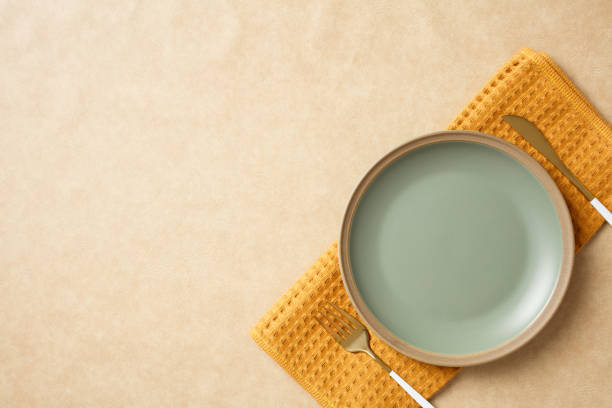 istock Minimalist ceramic bowl on textured yellow napkin, set against a neutral beige backdrop. Autumn, Fall dining concept. 2180507906
