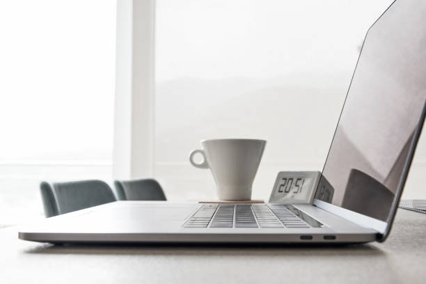 istock Modern laptop is placed on a desk with a blurred coffee cup and clock 2180508004