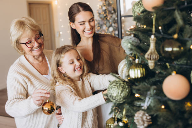 istock Family Decorating Christmas Tree Together With Joyful Smiles 2180509978