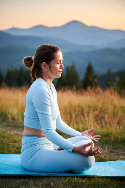 istock Woman practicing yoga outdoors in the mountains in a serene, natural setting. 2180511914
