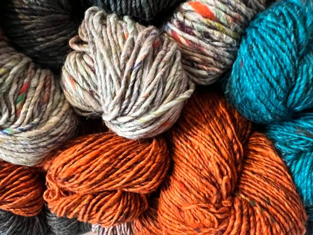 Display of textured yarns in rust, turquoise and beige. Ready to be knitted into garments