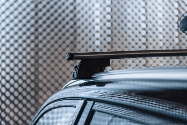 Car roof rack at night in a city. Close-up image of metal bar - front part of roof rack. car roof rails stock pictures, royalty-free photos & images