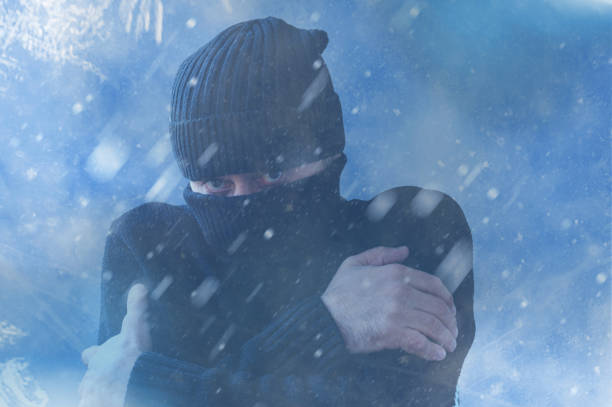 istock Frozen man shivering from cold weather on a blue snowy background. Winter cold concept 2180530480