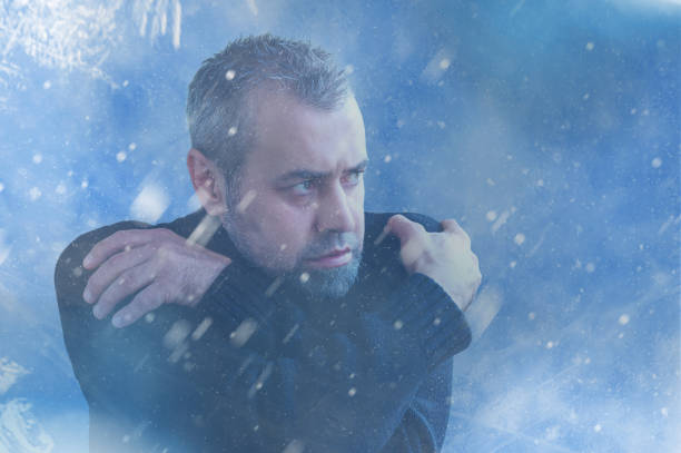 istock Frozen man shivering from cold weather on a blue snowy background. Winter cold concept 2180530495