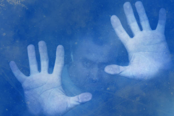 Frozen man with hand against a blue snowy background. Winter cold concept
