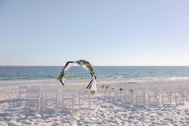 istock Beach wedding setup with floral arch by the ocean. 2180533091
