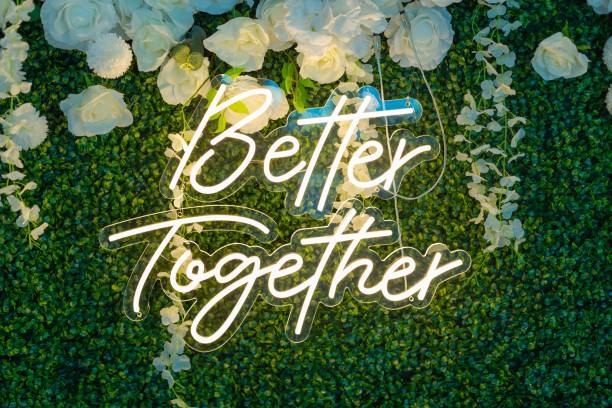 Neon 'Better Together' sign on floral wall