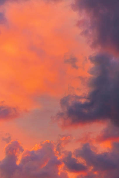Breathtaking sunset sky with vibrant orange and pink hues blending into dark, dramatic clouds