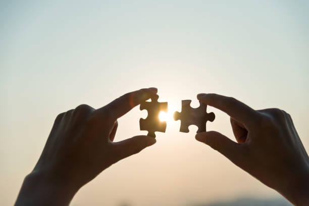 istock Woman hand putting puzzle pieces together in sunset 2180536221