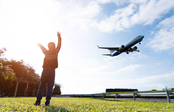 istock Boy arms raised and waving to the airplane 2180536489