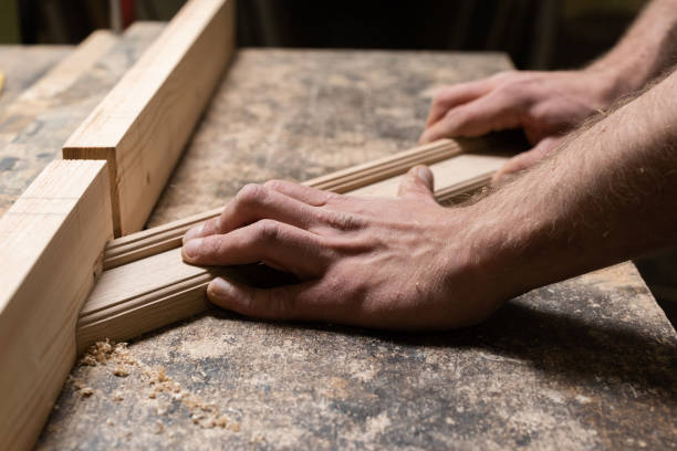 istock The carpenter holds an oak piece in his hands and makes a cut in it 2180546555