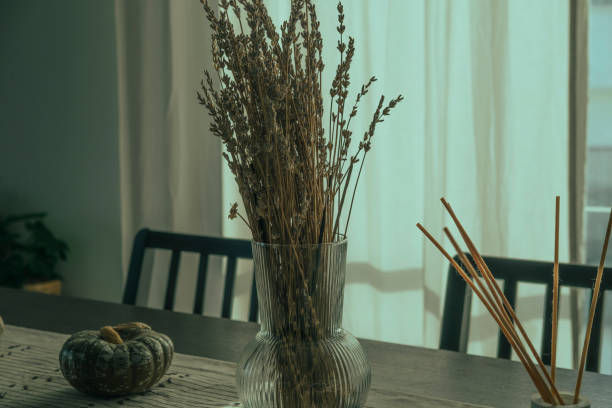 istock cozy autumn indoor interior decoration,, gray green pumpkin, table runner, day light through window linen curtains, glass vaze with ldry lavander, room scent sticks 2180553687