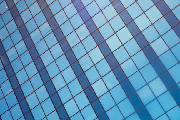 The blue tiles reflect fluffy white clouds in a striking modern architectural setting